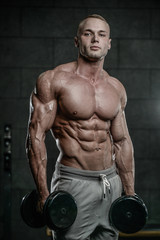 Fototapeta na wymiar Handsome model young man training abs in gym
