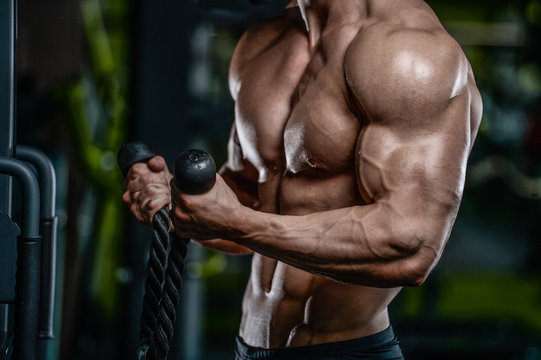 Handsome model young man training arms in gym