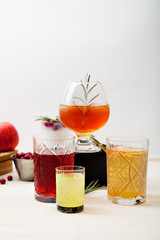 Set of various winter cocktails: mulled wine, eggnog, limoncello, old-fashioned, coconut margarita. White linen background. Vertical composition.