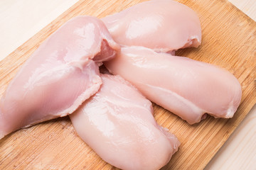 Fresh chicken fillet on a wooden cutting board