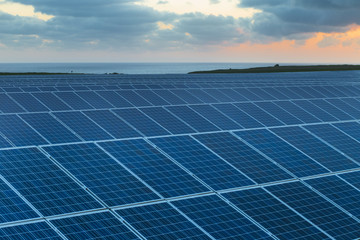 Solar panels at sunrise with cloudy sky in Normandy, France. Solar energy, modern electric power production technology, renewable energy concept. Environmentally friendly electricity production