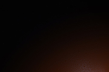 Water drops and small white spots scattered on a black backgroun