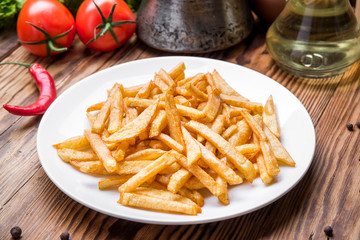 Tasty french fries on cutting board,  wooden table
