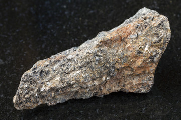 raw biotite nepheline syenite stone on dark
