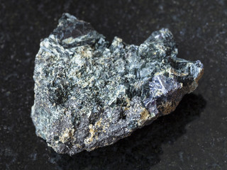 Molybdenite crystal in raw Glaucophane on dark