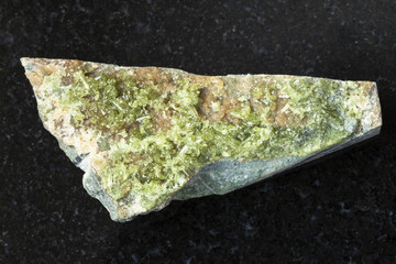 rough crystal of green Vesuvianite stone on dark