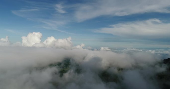 Aerial View. Flying over the beautiful mountain in clouds.