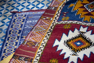 Colourful hand woven berber carpets spread on the bazaar floor in Morocco