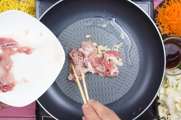 Chef putting slice of pork for cooking Yakisoba