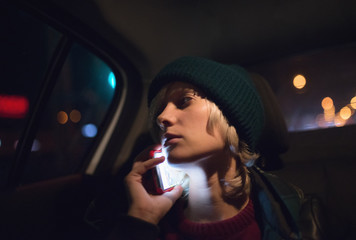 Young woman talking on mobile phone in taxi