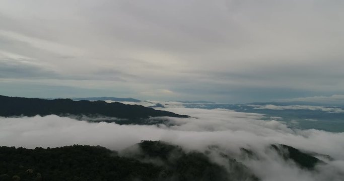 Aerial View. Flying over the beautiful mountain in clouds.