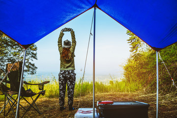 Asian women travel relax in the holiday. camping on the Mountain. Stand up look landscape on the mountain in the morning. Thailand