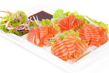 raw salmon with wasabi and sauce isolated on white plate on white background