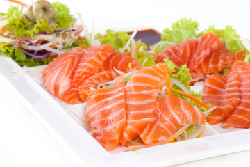 raw salmon with wasabi and sauce isolated on white plate on white background
