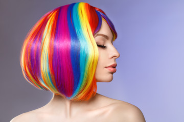 Woman hair as color splash. Rainbow up do short haircut. Beautiful young girl model with glowing  healthy skin.