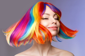 Woman hair as color splash. Rainbow up do short haircut. Beautiful young girl model with glowing  healthy skin.