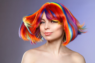 Woman hair as color splash. Rainbow up do short haircut. Beautiful young girl model with glowing  healthy skin.