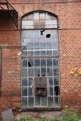 altes glasfenster in einer alten ziegelmauer aus roten ziegelsteinen