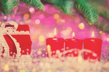 Christmas card. Background on a theme of New Year's  party. Decorated fir-tree with gifts and candles on the background of colorful festive lights. A magical evening.