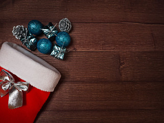 Red sock and silver, blue christmas decoration on wooden background. Place for inscription on the right. Feeling of Christmas.