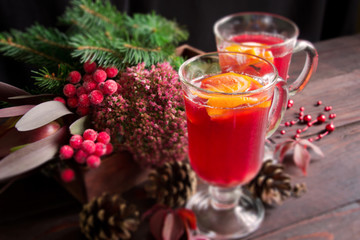 Mulled wine in glasses ,red berries,cones and autumn branches on wooden table.Autumn background.Selective focus