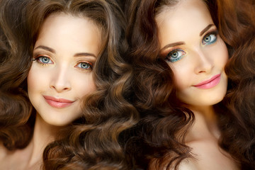 Obraz premium Young beautiful twins women with healthy skin and luxurious curly updo hair