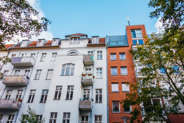 old and modern apartment house at berlin with white and red facade