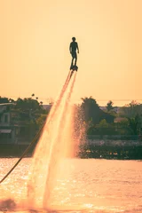 Foto op Canvas NONTHABURI, THAILAND - February 27 2015:  Silhouette and vintage color styl  of showing flyboard on Chaophya river during Chinese new year celebrations on February 27, 2015 Nonthaburi, Thailand. © suwanphoto