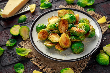Homemade Roasted Brussel Sprouts with Parmesan cheese, lemon, Salt, Pepper on a old stone rustic table.