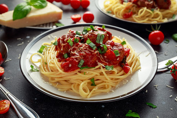 Spaghetti pasta meatballs with tomato sauce, basil, herbs parmesan cheese on dark background