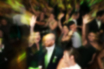 blurry background of men and women dance in nightclub