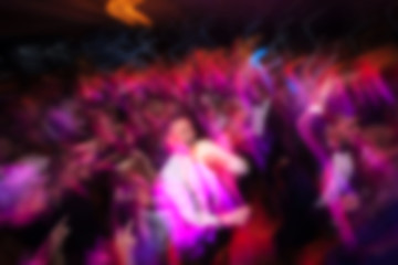 blurry background of men and women dance in nightclub