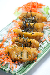 close up of gyoza with seaweed on top on white  table