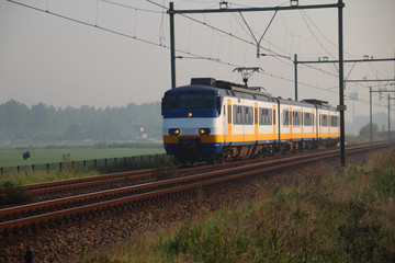 Local passenger train in Moordrecht in morning fog