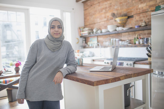 Muslim businesswoman wearing a hijab in her kitchen