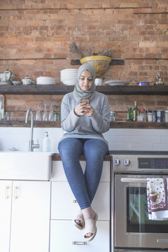 Muslim woman wearing a hijab using her smart phone