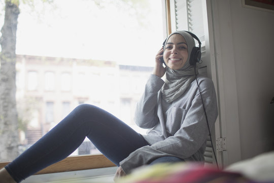 Muslim woman wearing a hijab listening to music