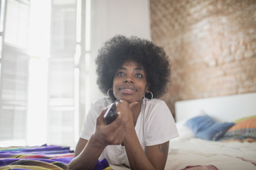 Woman watching television on her bed