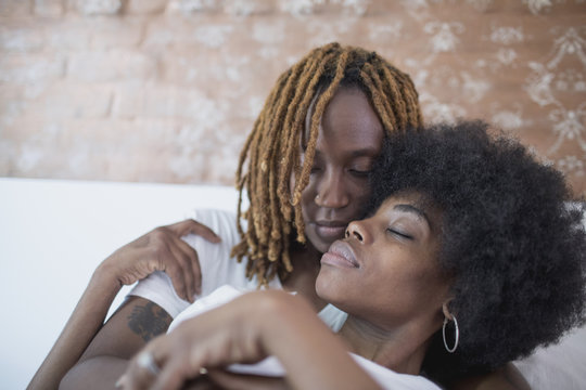 Lesbian couple embracing on bed
