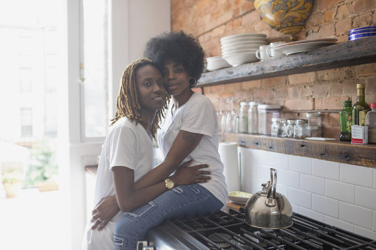 Lesbian couple embracing in their kitchen