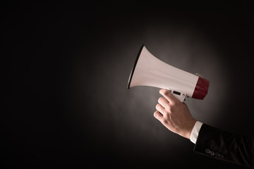 Hand of a businessman holding a megaphone