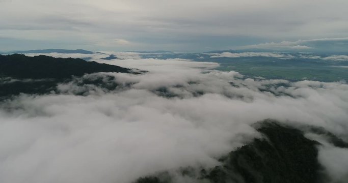 Aerial View. Flying over the beautiful mountain in clouds.