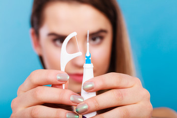 Woman holding small toothbrush and dental floss