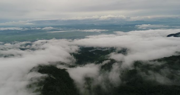 Aerial View. Flying over the beautiful mountain in clouds.