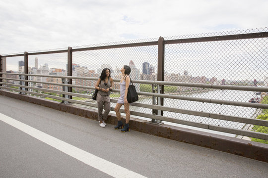 Friends talking on a bridge in Queens
