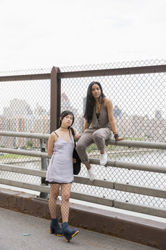 Portrait of young women posing on a bridge
