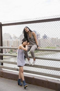 Portrait of young women posing on a bridge
