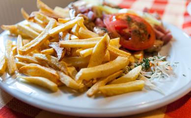 Straw potatoes , chicken breast , healthy vegetables on plate.
