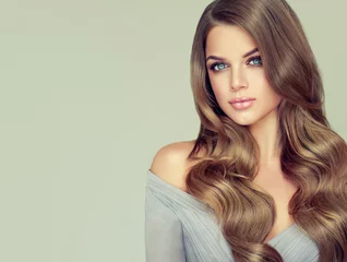 Photo sur Plexiglas Salon de coiffure Fille brune aux cheveux ondulés brillants longs et volumineux. Modèle de belle femme avec une coiffure frisée.