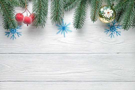 Christmas background. Branches of a Christmas tree, ball and small apples on a wooden background.